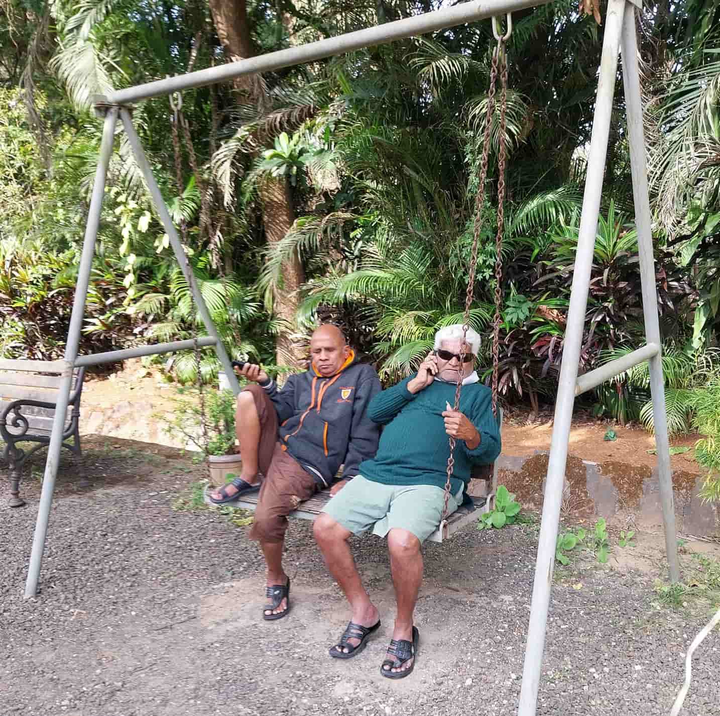 Two residents relaxing on a swing in the front lawn of the residence